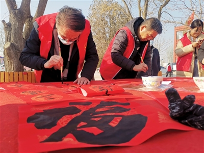 1月20日，在青銅峽市小壩鎮(zhèn)新林村村委會前的小廣場上，青銅峽市文化館工作人員為群眾免費書寫春聯(lián)。當(dāng)日，青銅峽市文化科技衛(wèi)生“三下鄉(xiāng)”暨“移風(fēng)易俗宣傳季”集中示范活動走進該村。
    本報記者 李娜 張懷民 攝