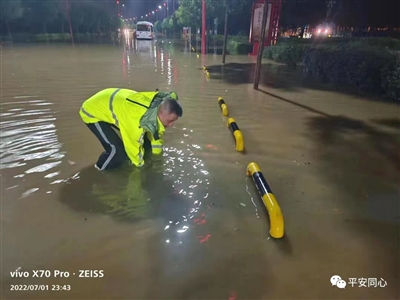 民警在積水中清理淤堵物。本報通訊員 蘇玉萍 攝